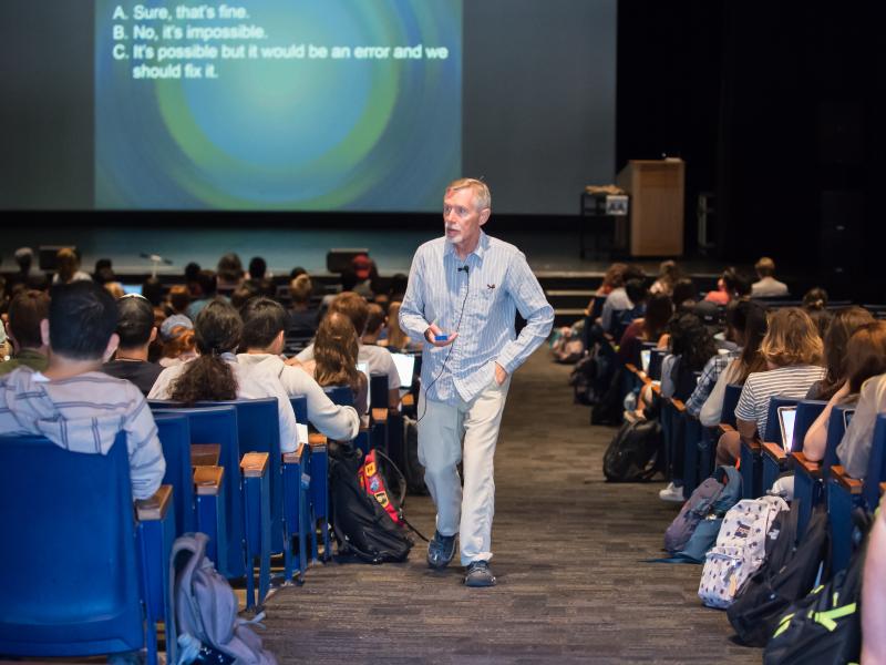 professor walking up an aisle in a lecture hall