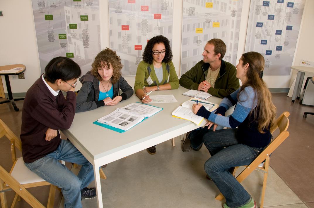 five people seated at a rectangular table